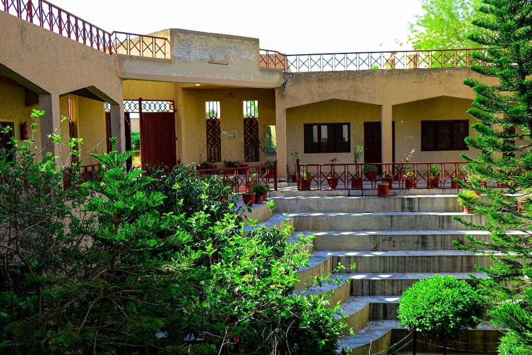 Terraced courtyard garden in front of an arched veranda on the Al-Asar campus